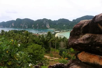 Traditional Thai longtail boats on the beach at Phi Phi Islands with limestone cliffs and turquoise water