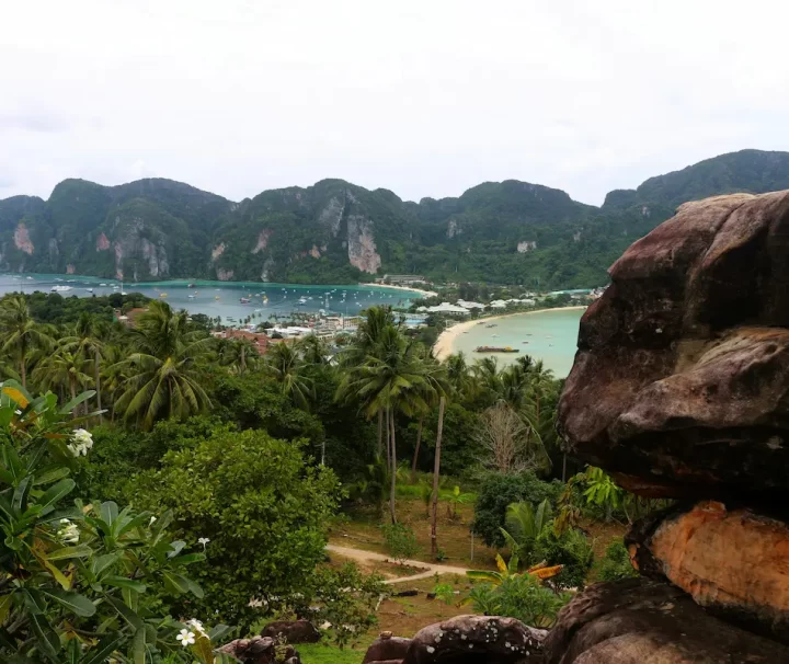 Traditional Thai longtail boats on the beach at Phi Phi Islands with limestone cliffs and turquoise water