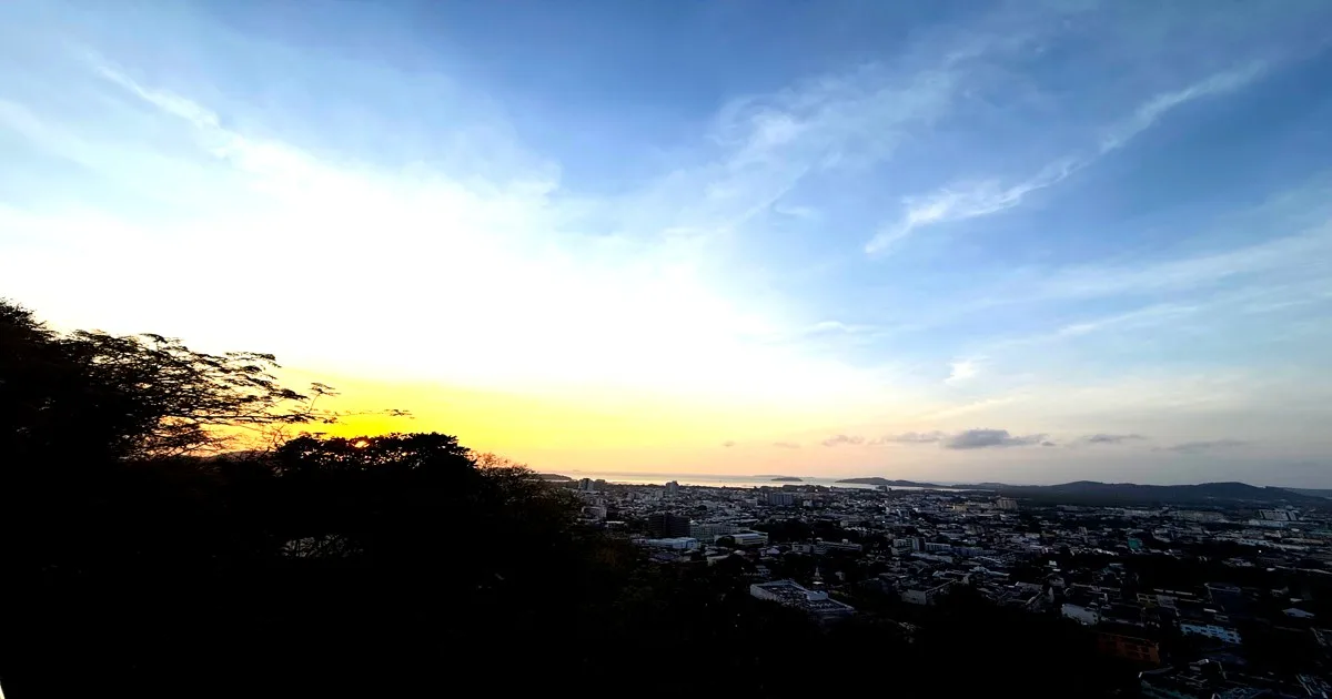 A stunning view from Radar Hill Viewpoint overlooking Patong Beach, Phuket, with golden sky hues and the city below.