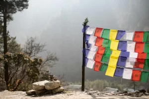Colorful prayer flags fluttering in the mountain breeze in Nepal with forest and mist in the background