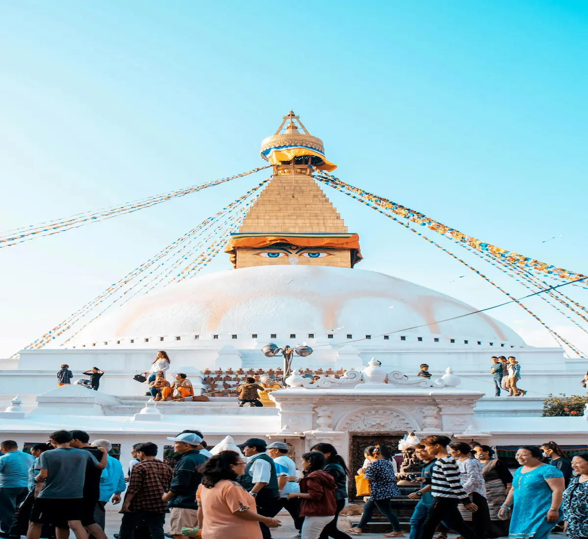Travelers walking past the iconic Boudhanath Stupa in Kathmandu, Nepal — a cultural and spiritual hub.