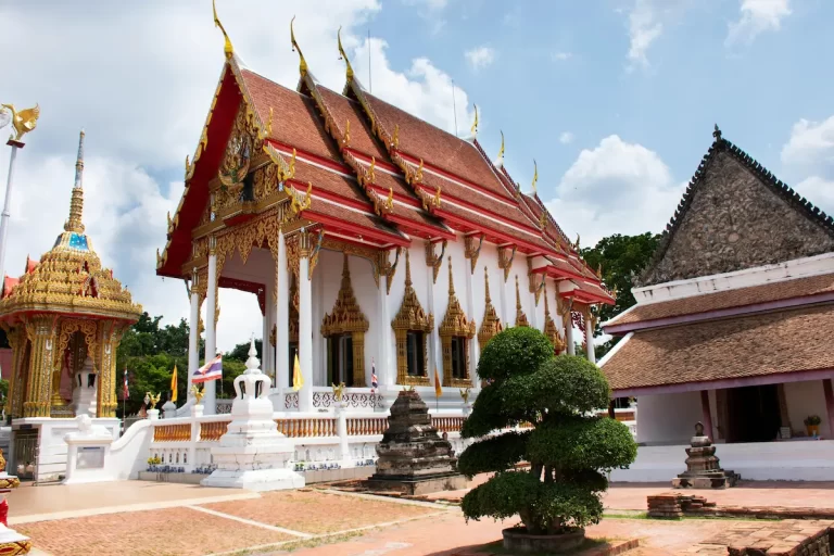Wat Chalong Temple in Phuket, Thailand, with intricate golden details and blue sky background