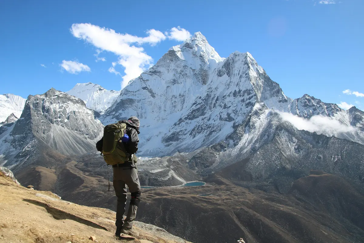 Backpacker hiking near Dingboche with snowy Himalayan peaks in Nepal
