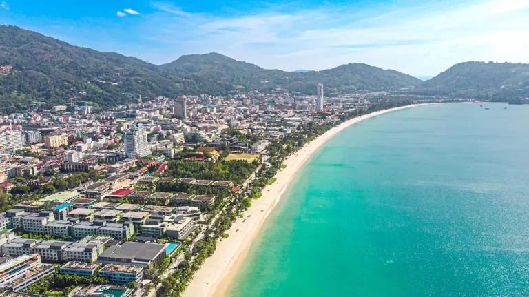Aerial view of Patong Beach Thailand with turquoise water, long sandy shoreline and the city backed by green hills