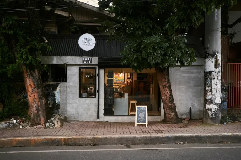 Street-level café and takeaway storefront showing everyday local rhythm when understanding what makes a place feel like it does
